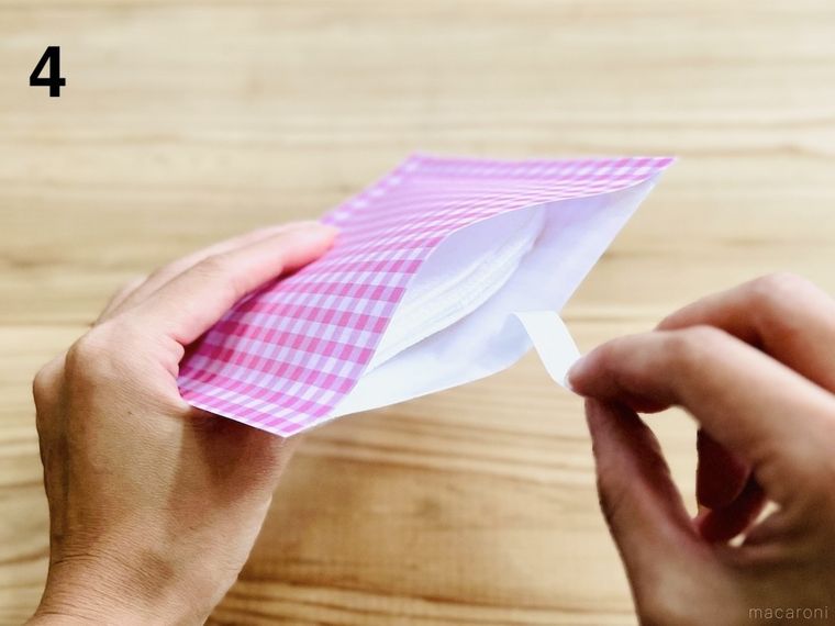 折り紙で作った袋の口を閉じている様子