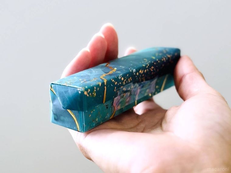 細長い箱状に折った折り紙を手で持っている様子