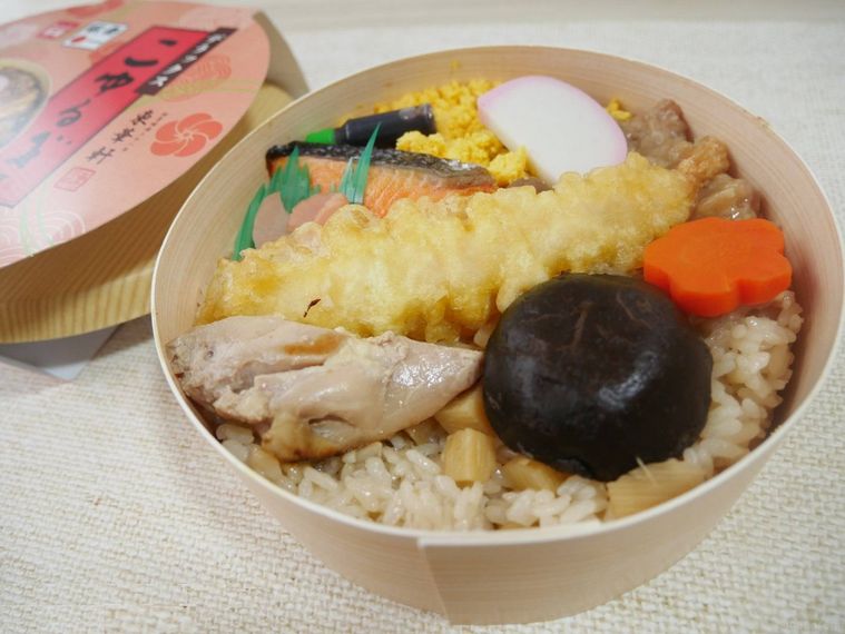 茶めしの上にえびの天ぷらやしいたけ、鶏肉や鮭がのった駅弁