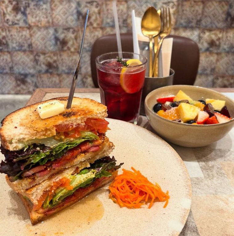 白いお皿に盛られたM.B.L.Tとフルーツボウルカシスブルーベリーソーダ