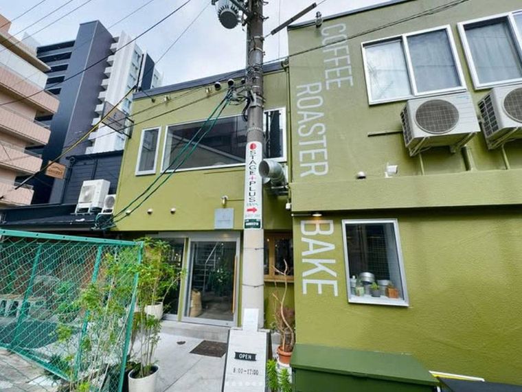 二階建てでグリーンの外壁が特徴的なシマトネリコ 路地裏 コーヒーロースターの外観