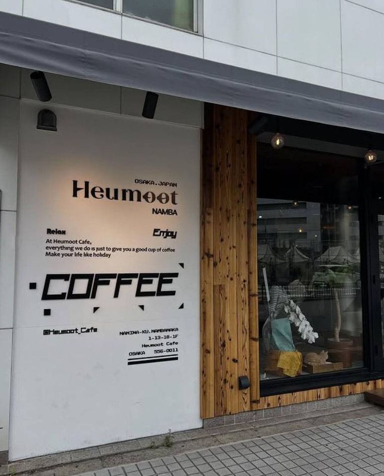 木の壁にモノトーンの大きな看板がかかったフムッ カフェの外観