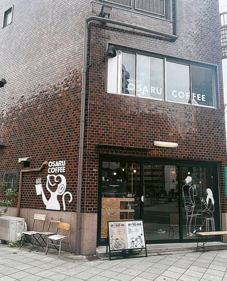 レンガの外壁にサルのイラストが描かれたオサルコーヒーの外観