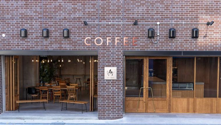 レンガの外壁に木の扉のアウンコーヒーロースターズの外観