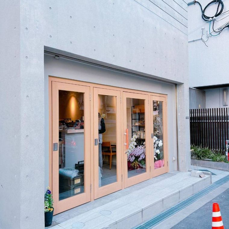 コンクリート調の外壁にガラスの木枠扉のあるピークローストコーヒーの外観