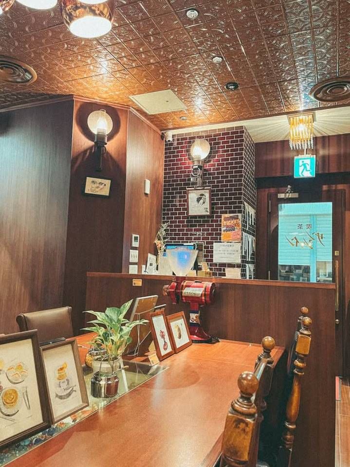 茶色を基調とした内装、木のテーブルセットが置かれた喫茶サンシャインの店内