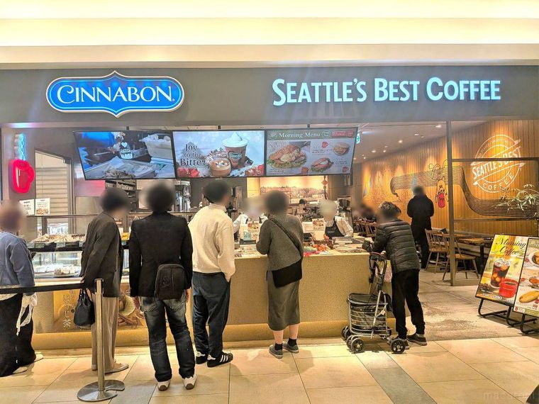 店名のロゴ入りの電飾看板がかかったシナボン・シアトルズベストコーヒー ルクア大阪店の外観