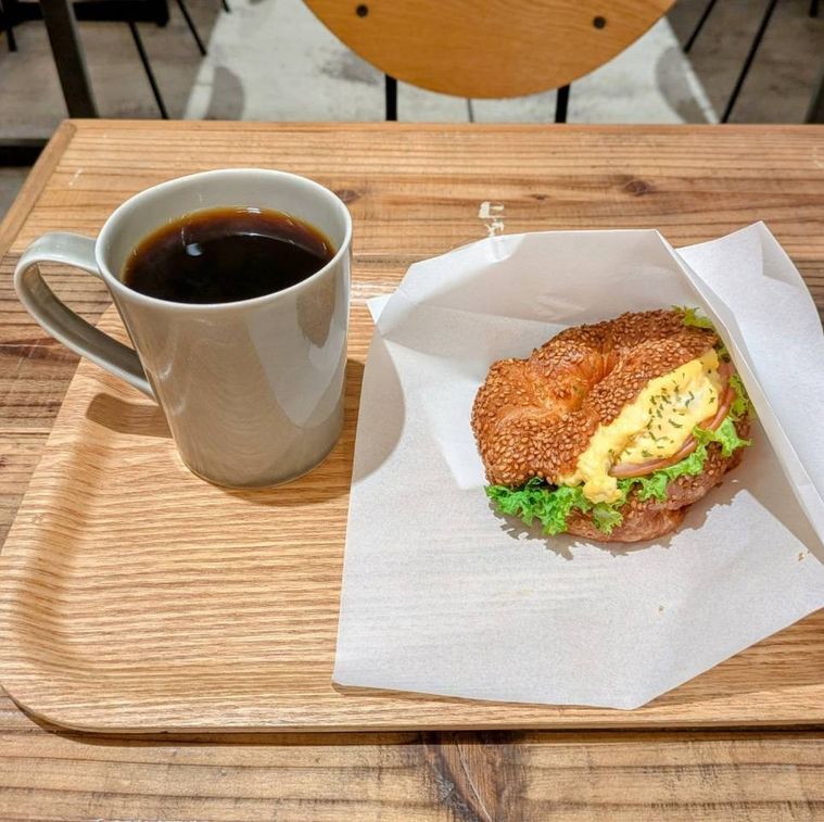 木のトレイにのせられたセサミクロワッサン ハムエッグとモーニングコーヒー