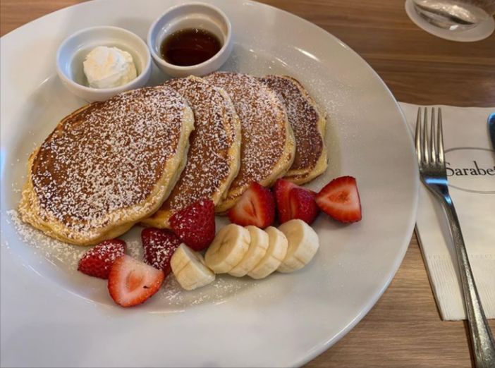 白いお皿にパンケーキといちご、バナナがのっている