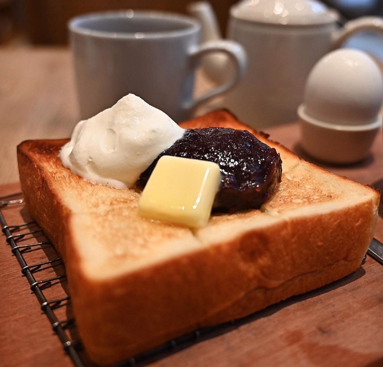 木のトレーと網にのった、生クリーム、バター、あんこの小倉トースト、ゆで卵。