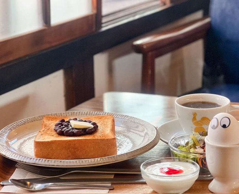 木のテーブル、グレーのお皿にのった小倉トースト、サラダ、ヨーグルト、コーヒー