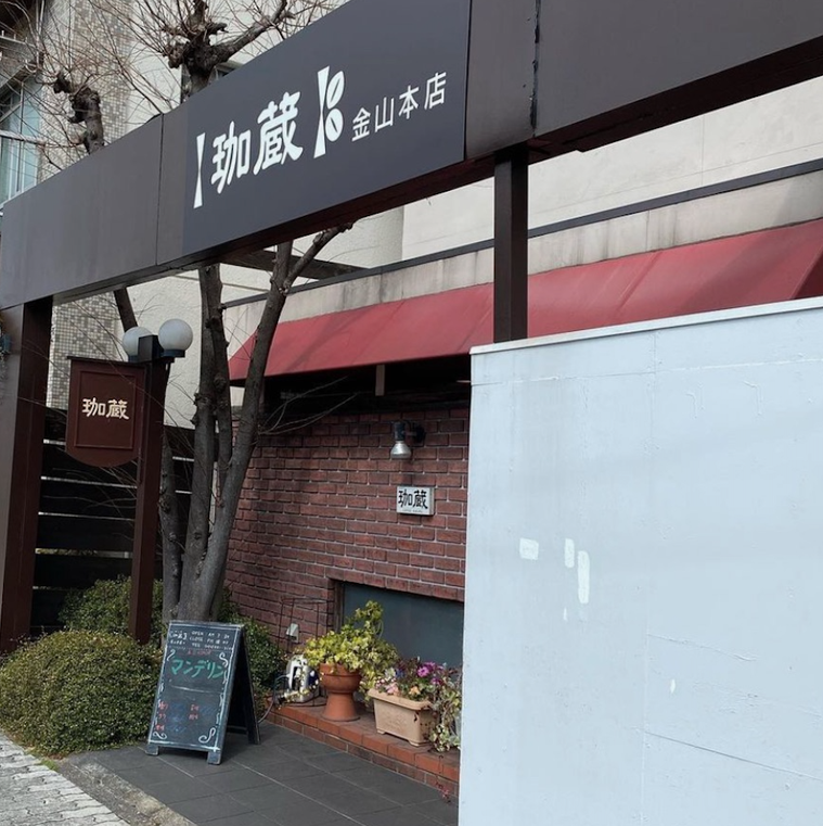 煉瓦づくりの外壁と赤い屋根。白い壁、白い文字の屋号