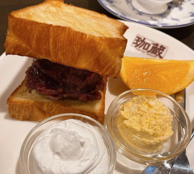 白いお皿にのった小倉デニッシュ、生クリーム、サラダ、オレンジ