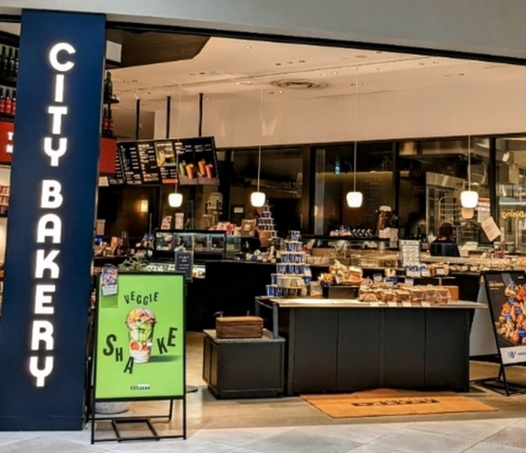 緑の看板や屋号が縦に書かれた紺色の看板にパンが並ぶ店内