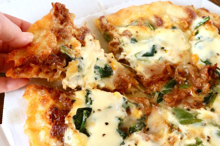 とろけるチーズのピザーラプルコギを手でとっている