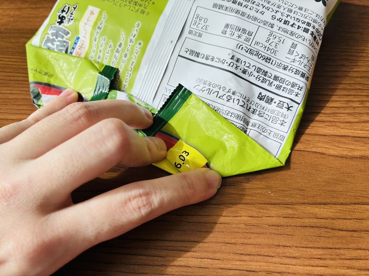 ポテチ袋の口を折って折り目を付けている