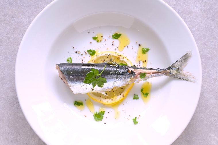レモンの上にゆでさんまが盛り付けられていてパセリ、塩こしょう、オリーブオイルが振りかけられている