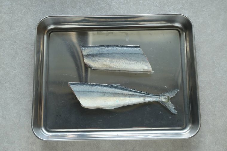 二等分したさんまが調理用バットに置いてある