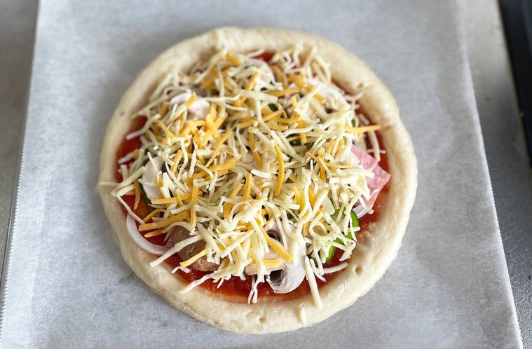 ピザクラフトに具材とチーズをトッピングした写真