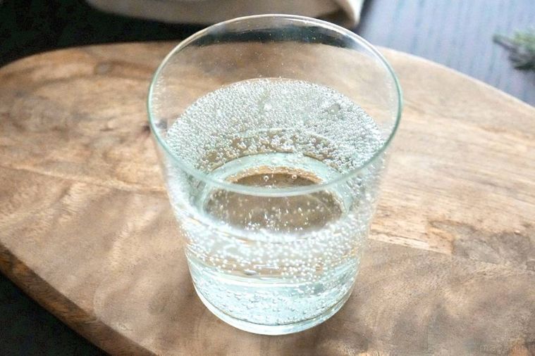 木のカッティングボードにのったグラスとふじりんごの缶チューハイ