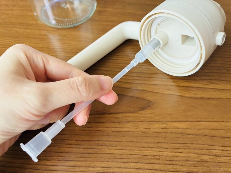 オイルスプレーのフタ裏にチューブを差し込んでいる