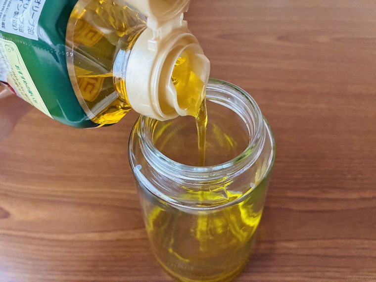 オイルスプレーボトルに油を注ぎ入れている