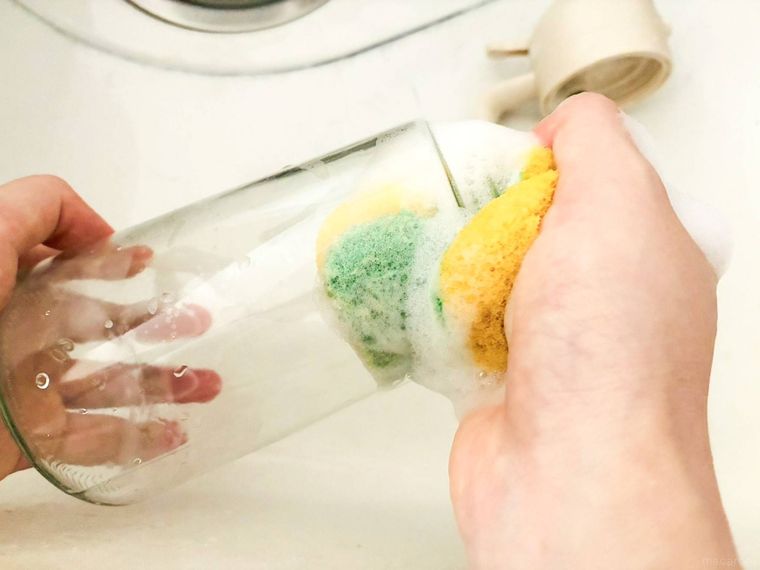 オイルスプレーボトルをスポンジで洗っている