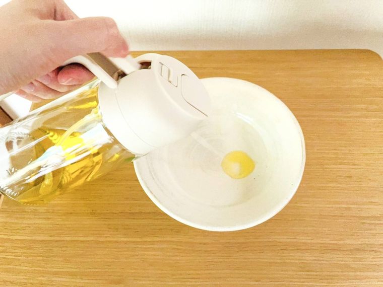 オイルスプレーボトルから皿の上に油をスプレーしている