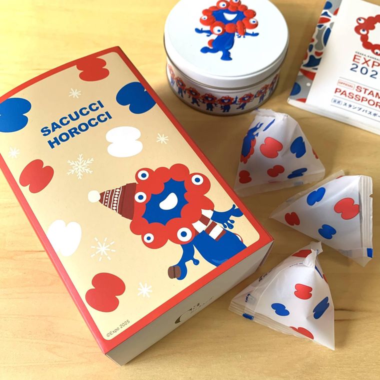 テーブルに置いたお菓子冬のミャクミャク サクッチ・ホロッチとお菓子の缶