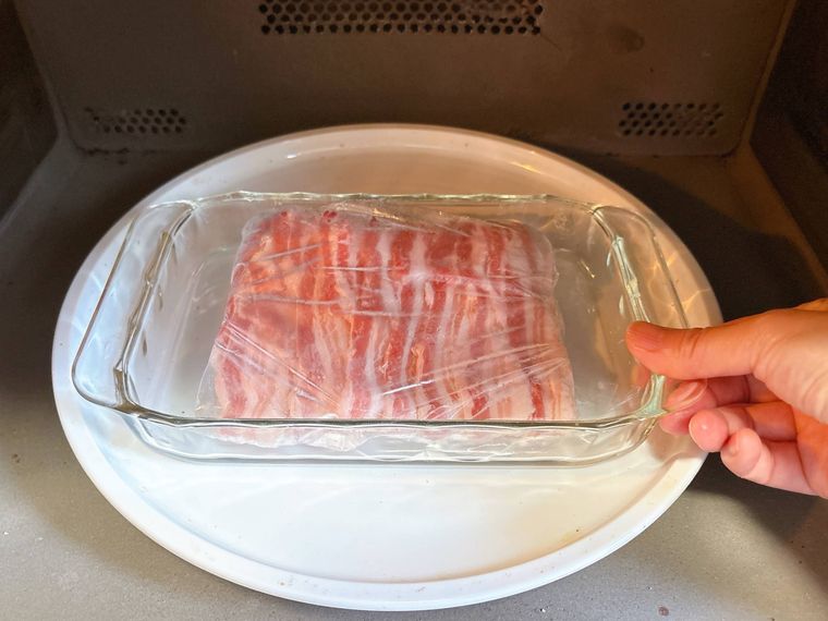 耐熱皿にのせた冷凍肉を電子レンジに入れる様子