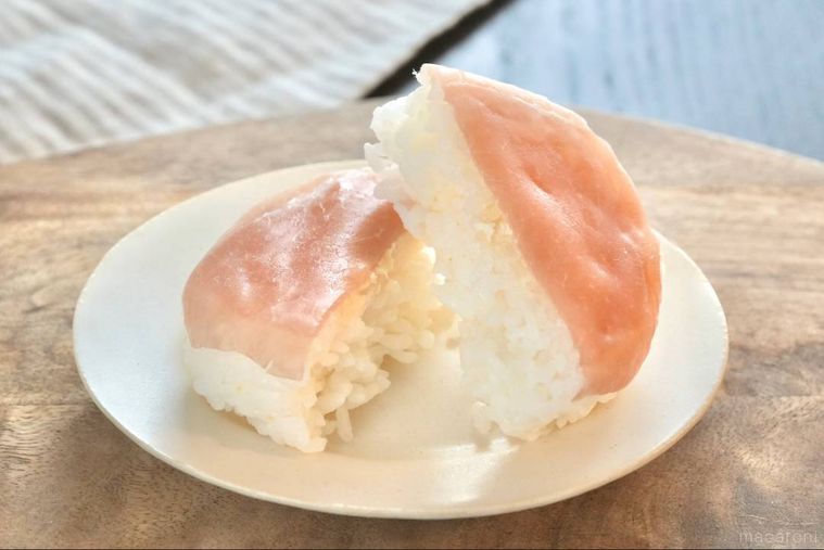 木のカッティングボードと白い皿にのった生ハム寿司の断面