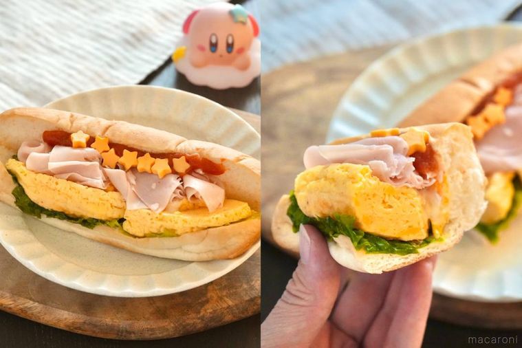 木のカッティングボードと白い皿にのったハムと卵のロールサンドを手に持つ様子