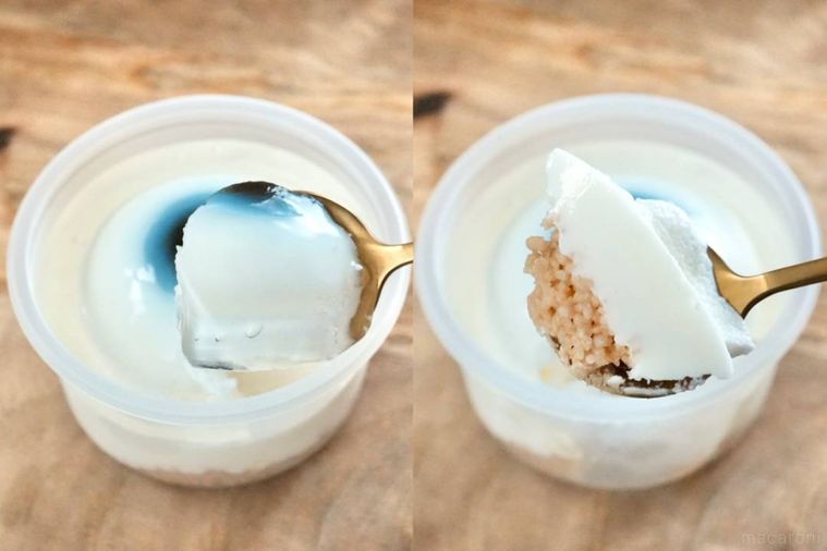 木のカッティングボードにのった目玉のレアチーズケーキを金のスプーンで食べる様子