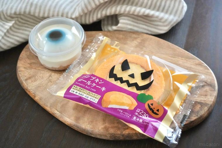 木のカッティングボードにのった目玉のレアチーズケーキとハロウィンかぼちゃのロールケーキ
