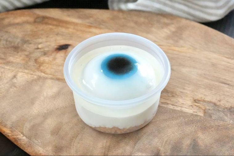 木のカッティングボードにのった目玉のレアチーズケーキ