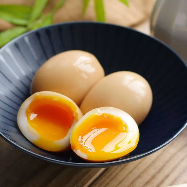 黒い皿にのった半熟卵とその断面