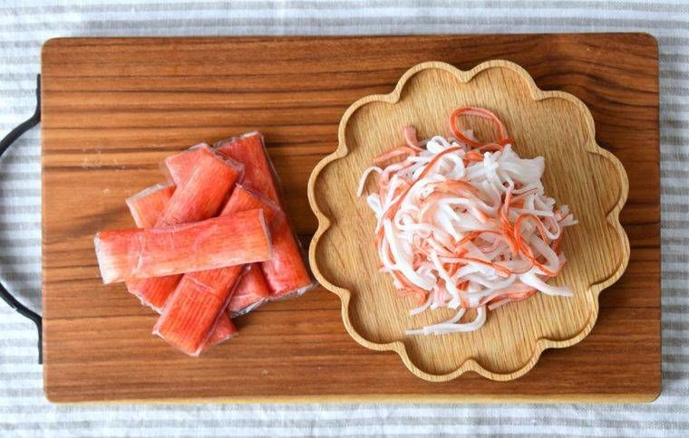 木製ボードの上にカニカマとほぐされたカニカマが盛られている