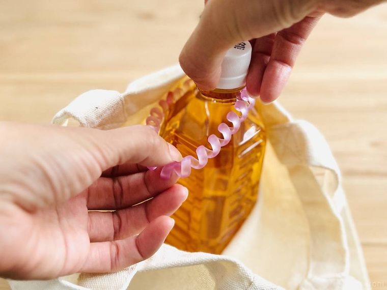 鞄の内側に付けたヘアゴムにペットボオルを通している様子