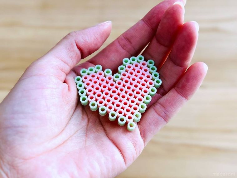 アイロンビーズで作ったハート型の作品を手で持っている様子