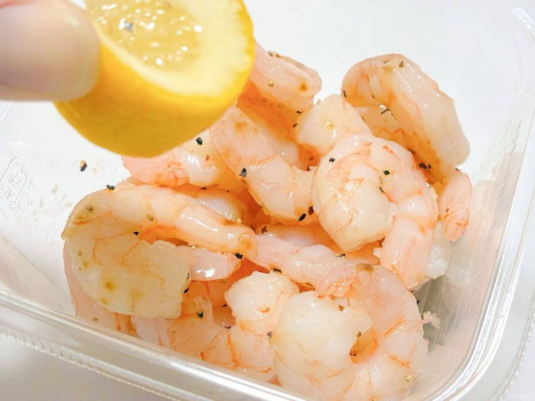 レモンを絞っている超シュリンプカクテルサラダ