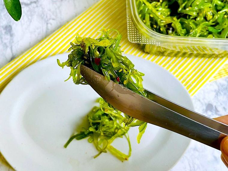 コストコのごまわかめをトングで皿に取り分けているところ