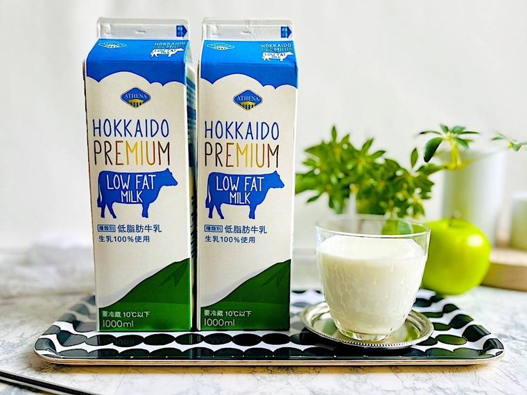 コストコの低脂肪牛乳を入れたグラスと2本の牛乳パックを並べたところ
