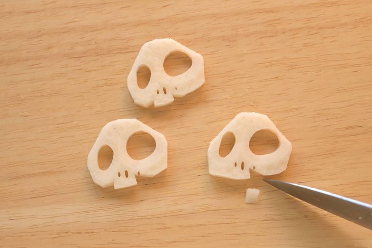 れんこんを包丁でガイコツ型に整える様子