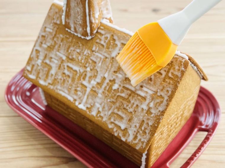 おかしの家の屋根にアイシングを塗っている様子