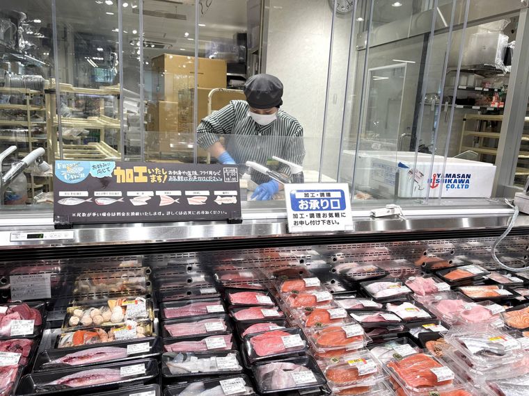 魚売り場でスタッフが魚を捌いている