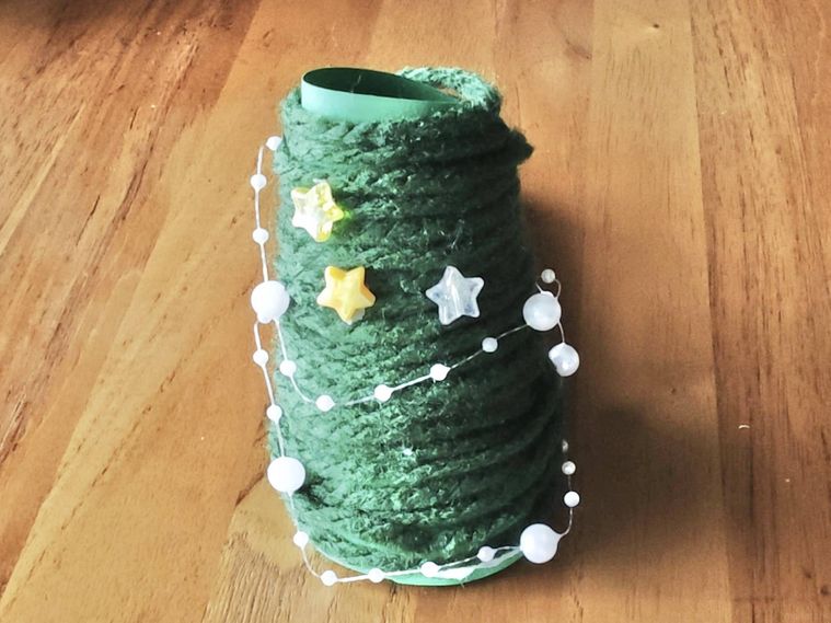 毛糸で作られたクリスマスツリーが机の上に置いてある