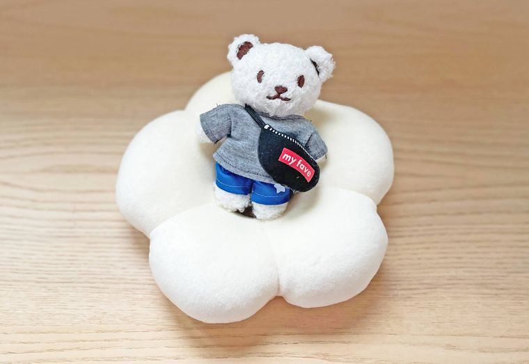 クマのぬいぐるみをのせた花形クッション