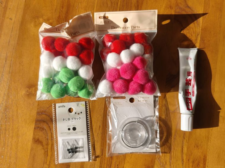 ポンポンで作る雪だるま付きのリースに必要な道具が机の上に置いてある