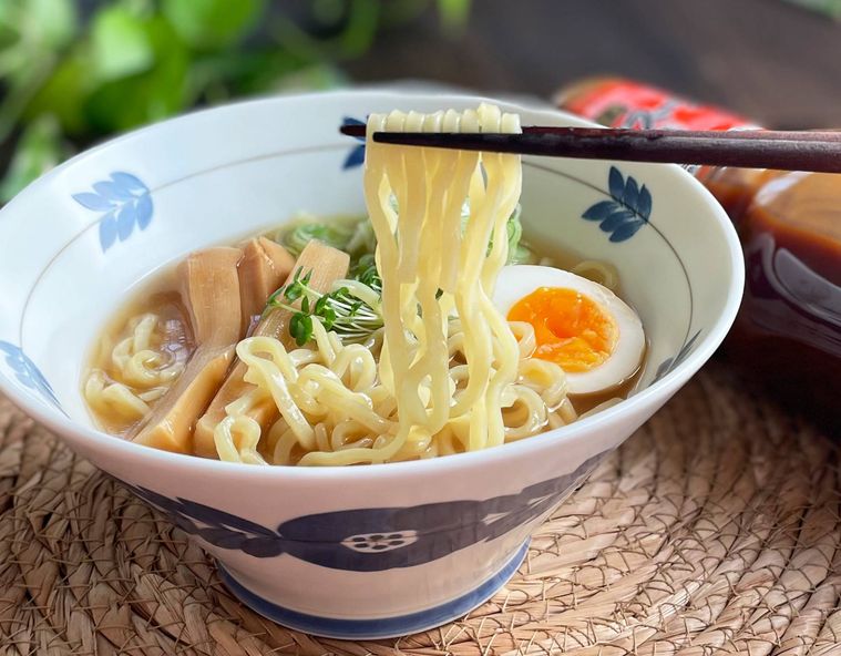 ラーメンの麺を箸ですくっている写真
