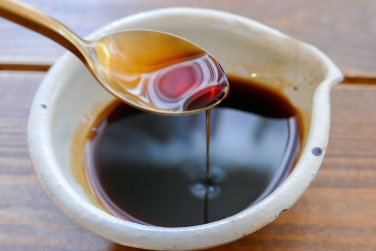 照り焼きのタレをスプーンですくい落とす様子